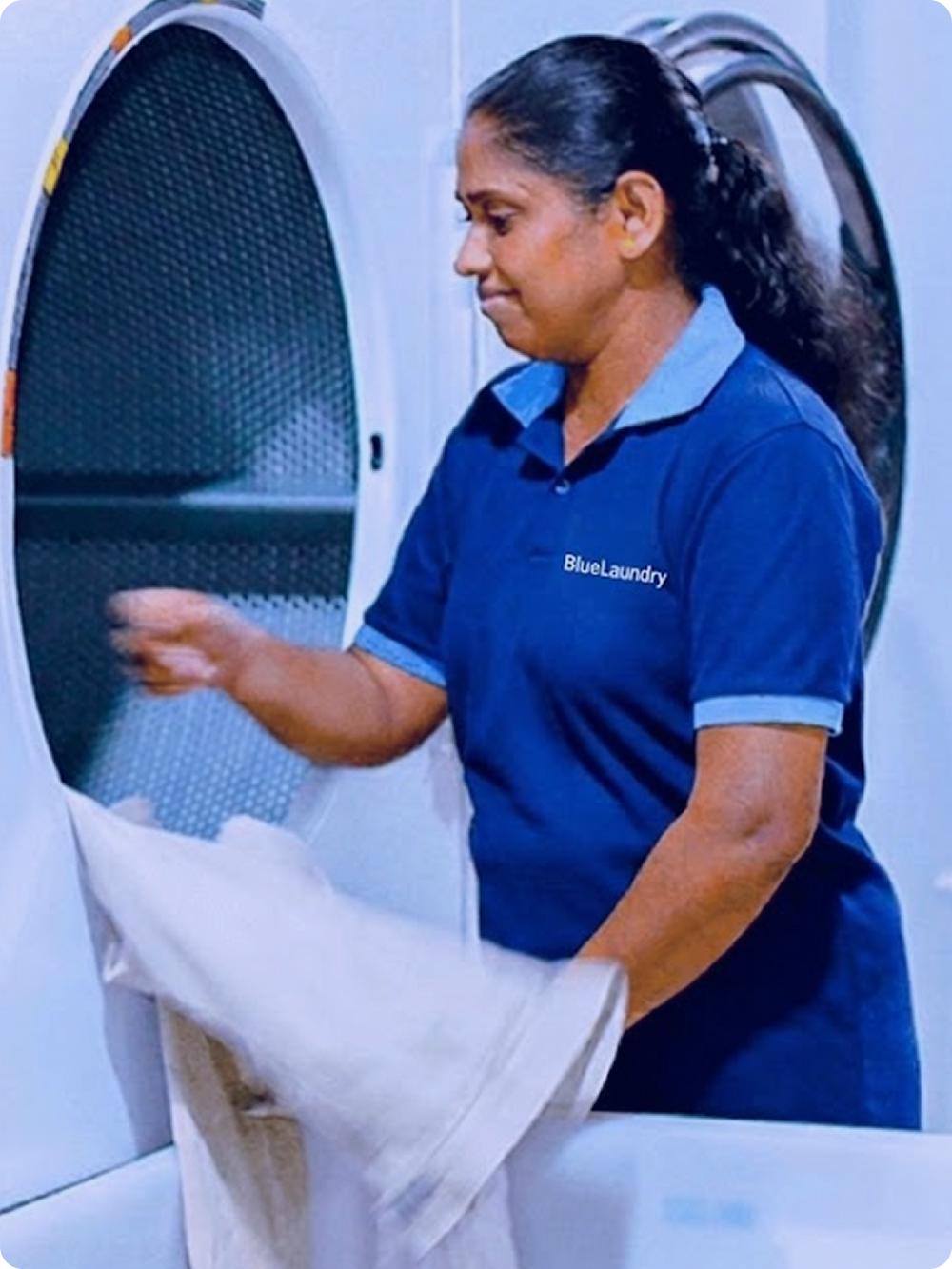 Une employée BlueLaundry pliant du linge avec soin