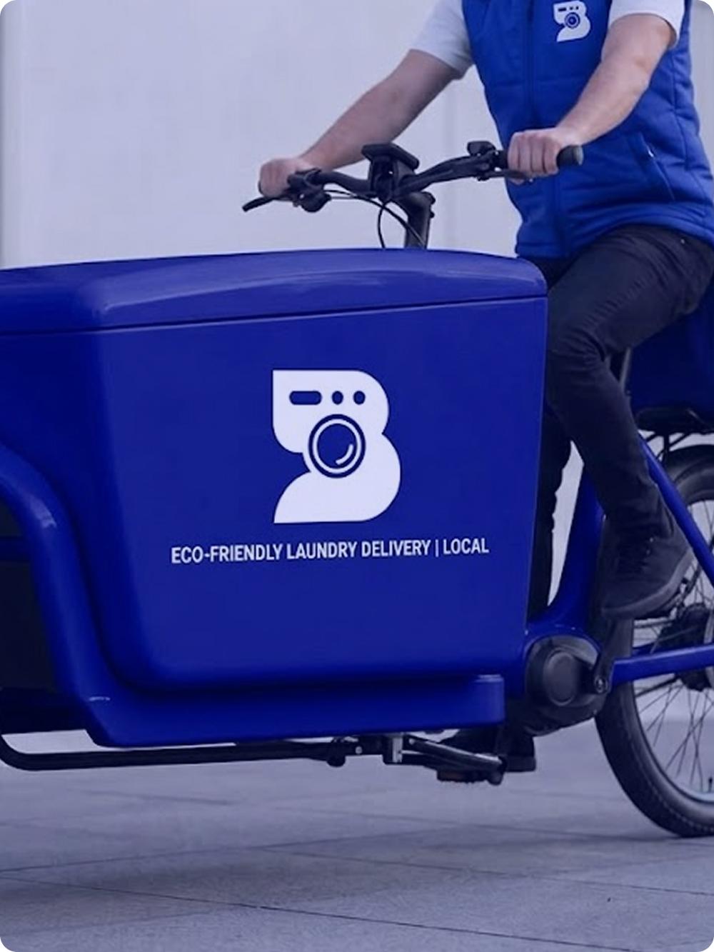 Livreur BlueLaundry se déplaçant à vélo cargo électrique